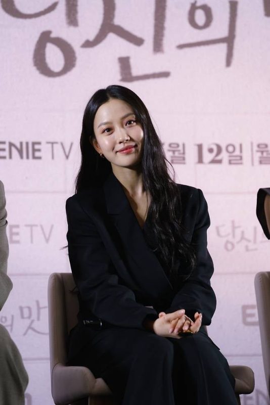 tastefully yours go min-si accentwoman-blackSuit-smiling-indoor.