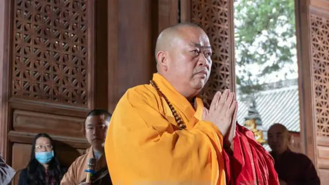 Shi Yongxin Shaolin Temple film industrymonk' 'prayer' 'orange' 'robe' 'temple.