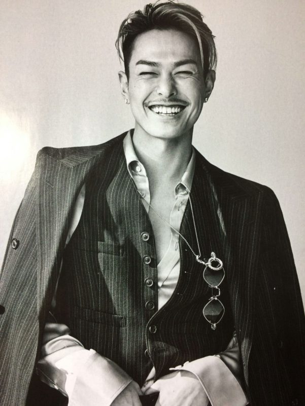 Imaichi Ryuji taxi assault investigationman' 'smiling' 'portrait' 'suit' 'monocle.