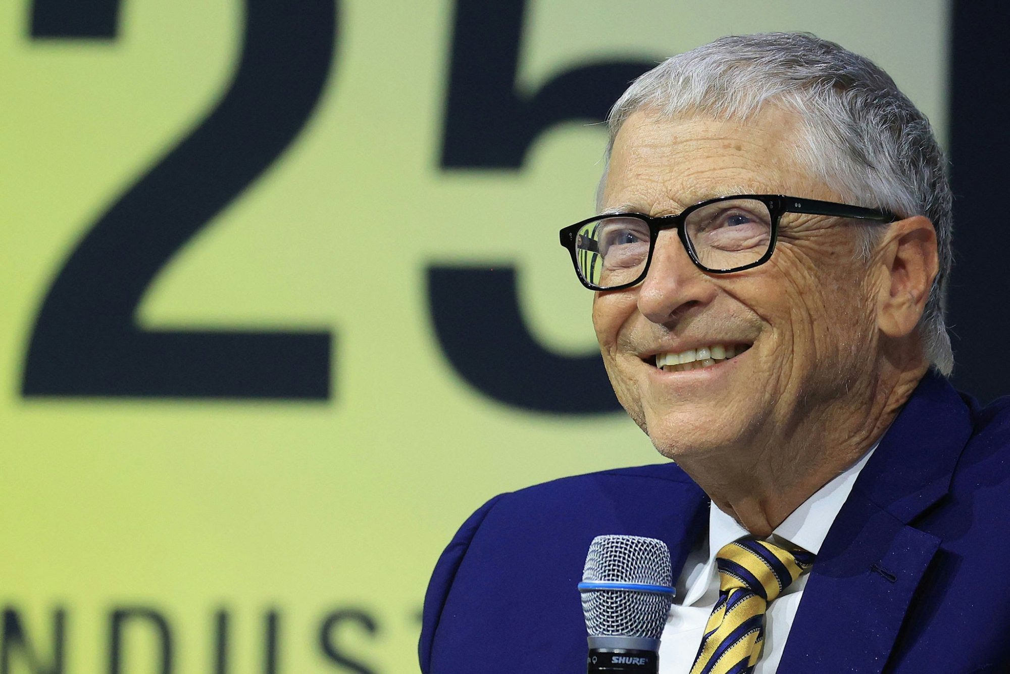 Bill Gates You Quiz on the Block appearancepeople' '' 'ill' '' 'ates' 'speaking' 'microphone' 'suit.