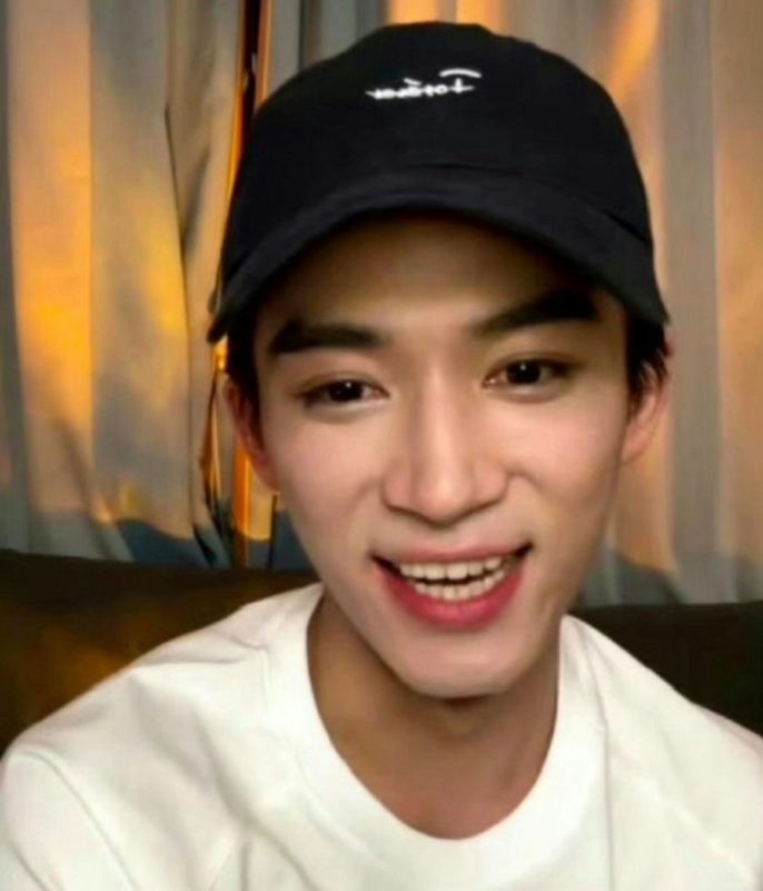 Chinese male actors lose visuals when smilingperson' 'smiling' 'baseball' 'cap' 'indoors' 'curtains.