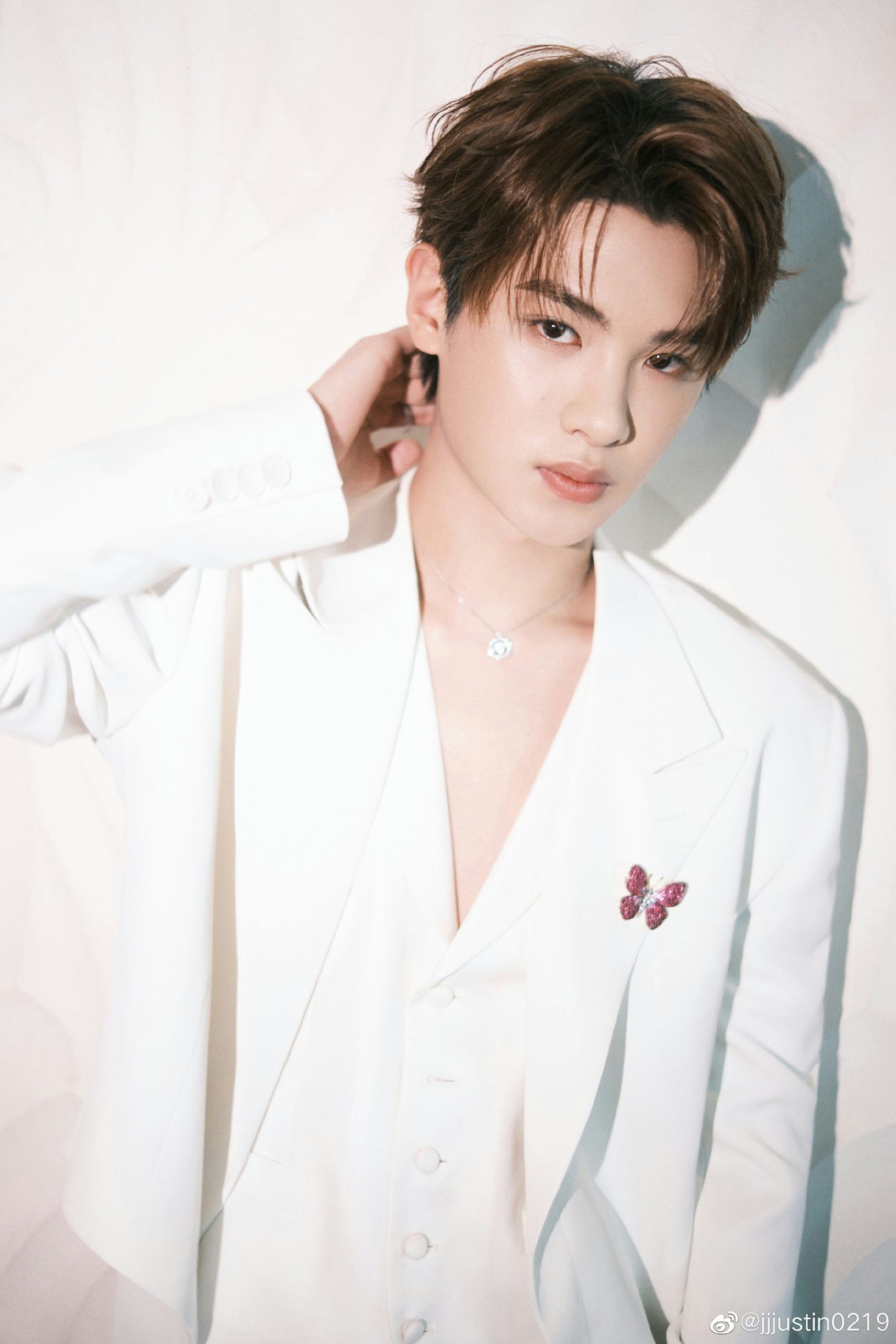 Justin Huang hidden cameraperson' 'white' 'suit' 'butterfly' 'pin' 'necklace' 'shadow.