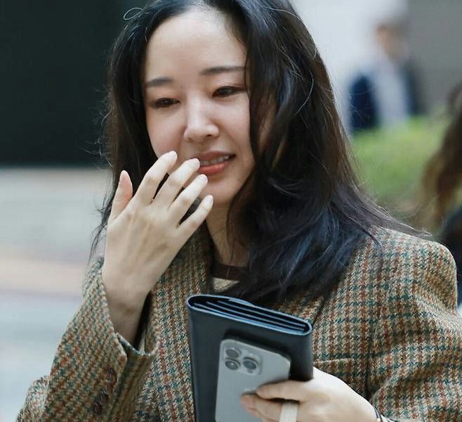 Min Hee Jin HYBE lawsuit Japanese investorspeople' 'woman' 'jacket' 'phone' 'outdoors.