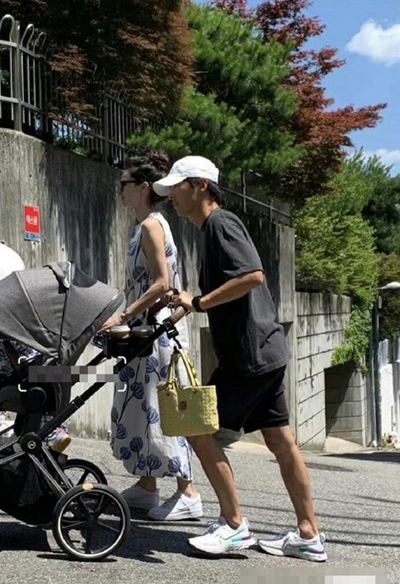 Song Joong-ki 40th birthday family updatepeople' 'stroller' 'walking' 'road' 'trees.