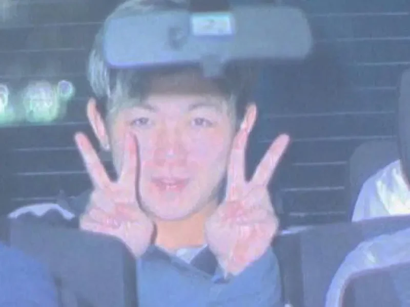 japan kidnap suspect v sign police car