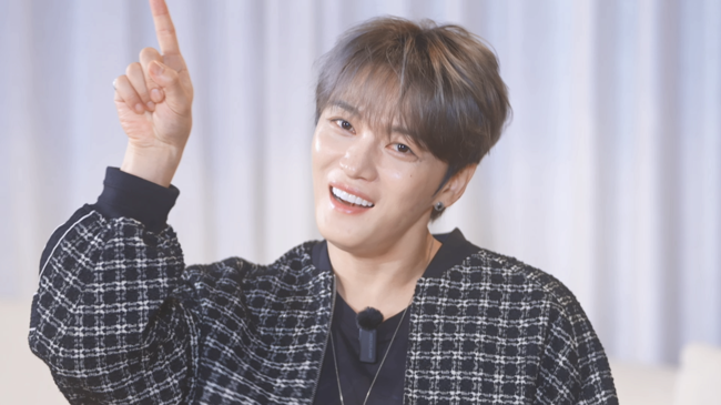 Kim Jaejoong female celebrity approachesperson' 'smiling' 'pointing' 'plaid' 'jacket.