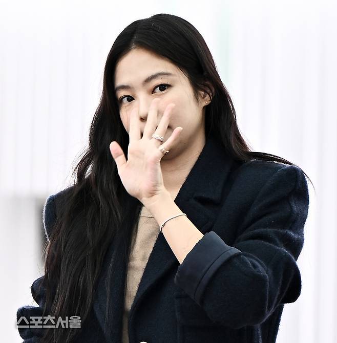 Jennie Chanel airport fashionwoman' 'covering' 'face' 'jewelry' 'coat' 'brunette.