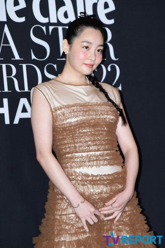 people-1-woman-A-brown ruffled dress-B-black background with white text-C-braided hair