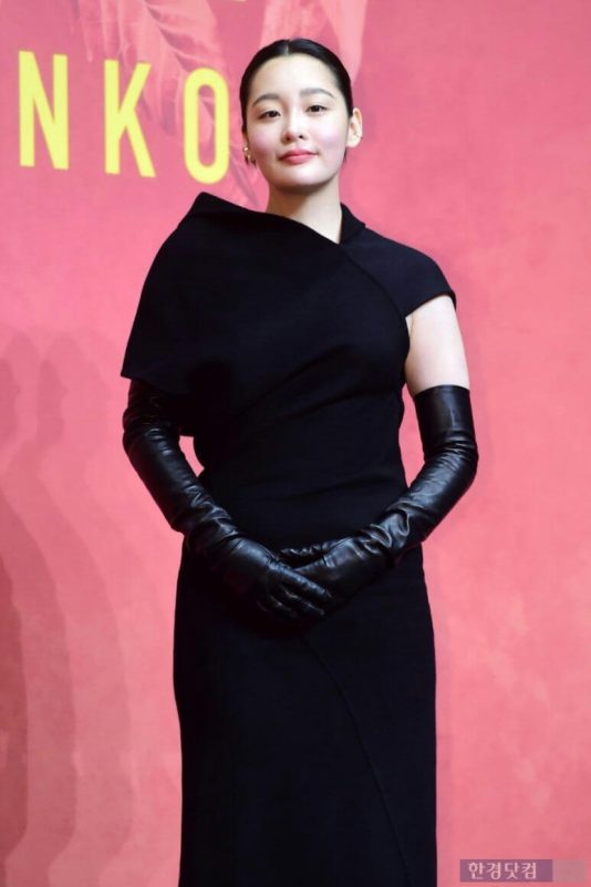 people-woman-black dress-black opera gloves-pink background-bun hairstyle