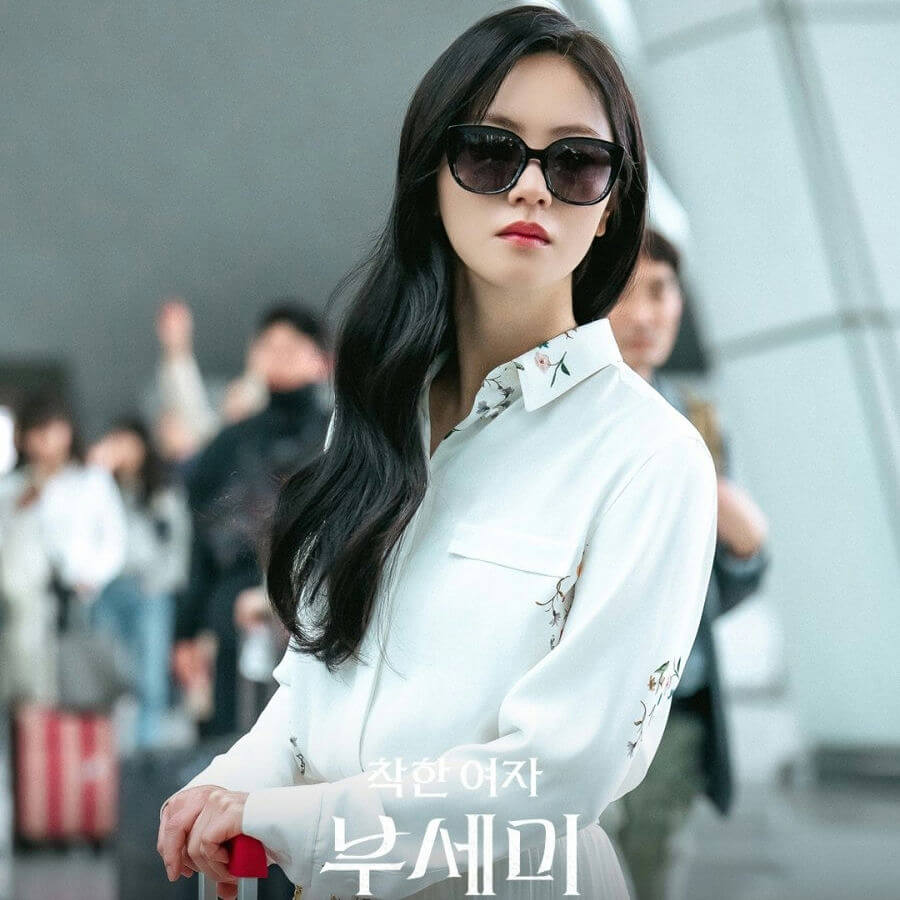 people-woman-A-sunglasses-A-white floral shirt-A-black wavy hair-A-airport crowd