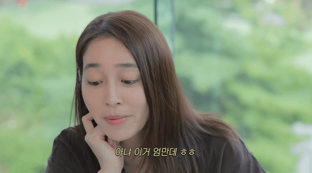 people-woman-brown hair-indoors-Korean subtitles-leaning head on hand-green blurred background