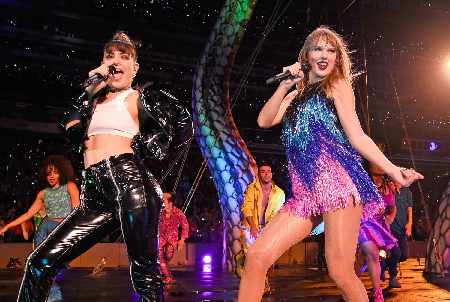 people-Two-female-singers-performing-on-stage-A-Taylor-Swift-B-Charli-XCX-C-performers-and-audience-in-background