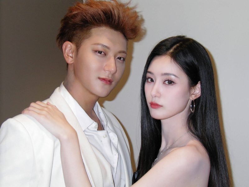 people-Two East Asian celebrities-A-Man with light brown hair and white suit-A-Woman with long black hair and off-shoulder top-A-Close up portrait