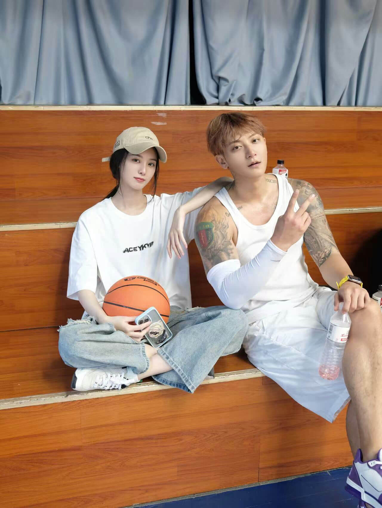 people-A-young woman-A-tan baseball cap-A-white t-shirt-B-young man-B-white tank top-B-arm tattoos-B-peace sign-C-couple-C-basketball-C-bleachers