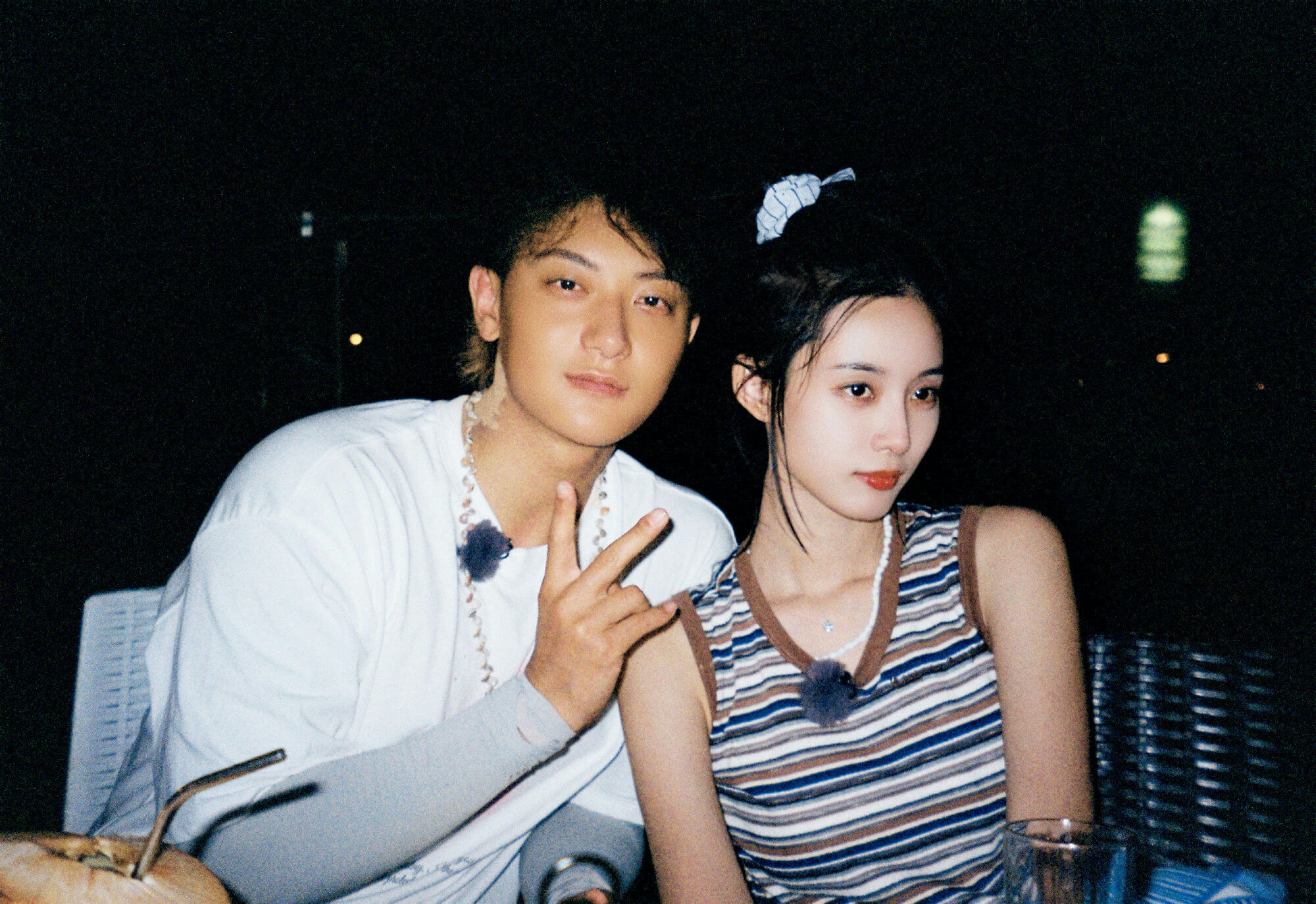 people-two-night-setting-A-male-gesturing-peace-sign-B-female-striped-top-C-casual-outfit