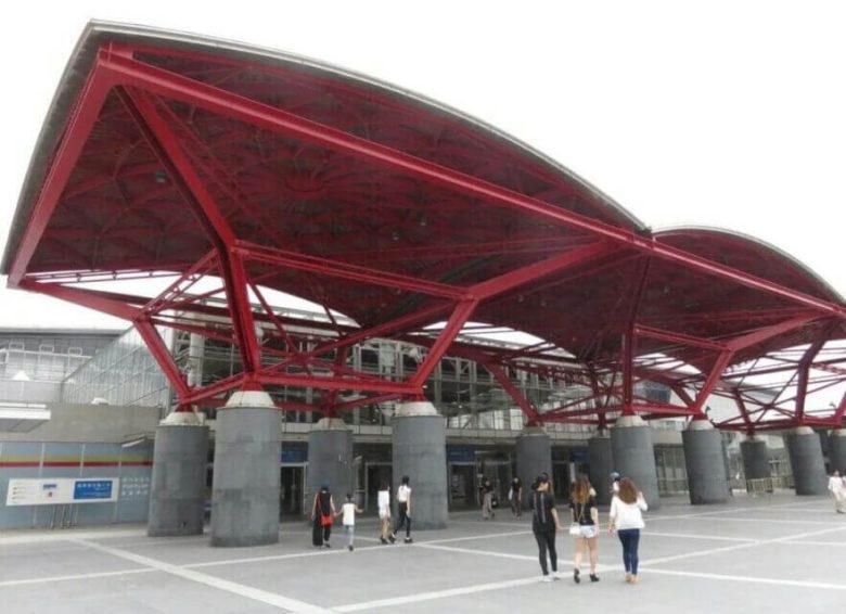 people-Several people-A-entrance-A-modern-A-red-A-canopy-B-structural-B-building-C-plaza