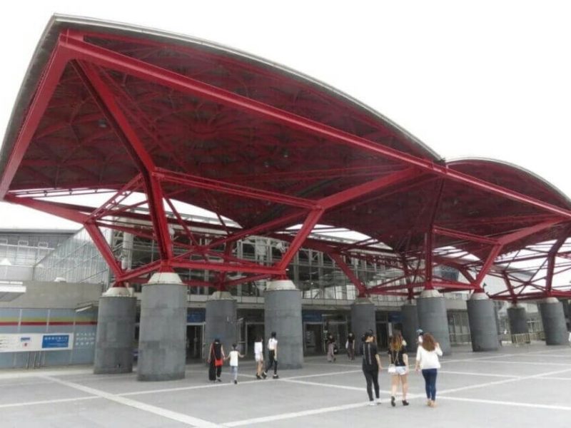 people-Several people-A-entrance-A-modern-A-red-A-canopy-B-structural-B-building-C-plaza