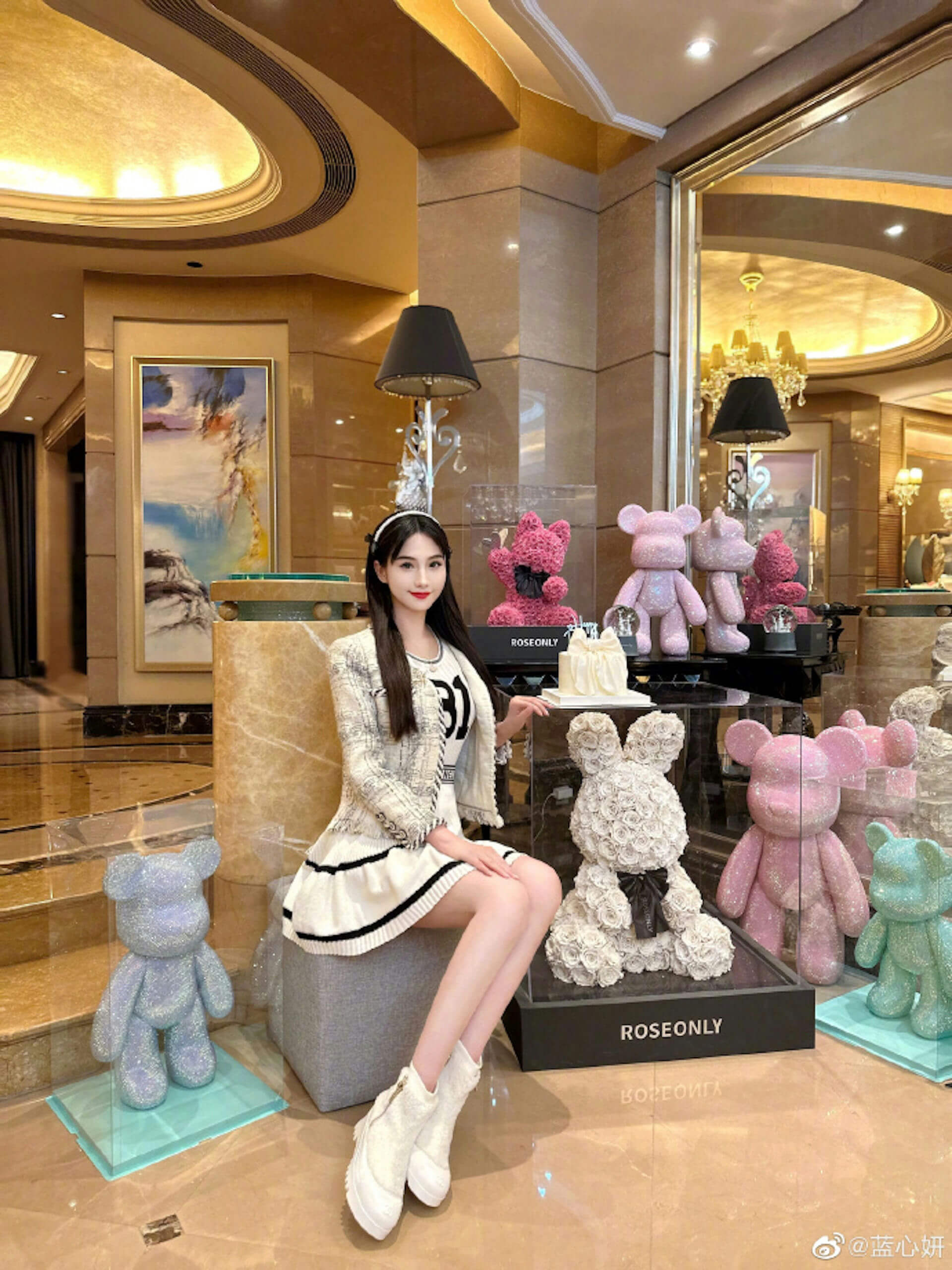 people-woman-A-sitting-B-wearing-white-tweed-outfit-C-surrounded-by-decorative-teddy-bears