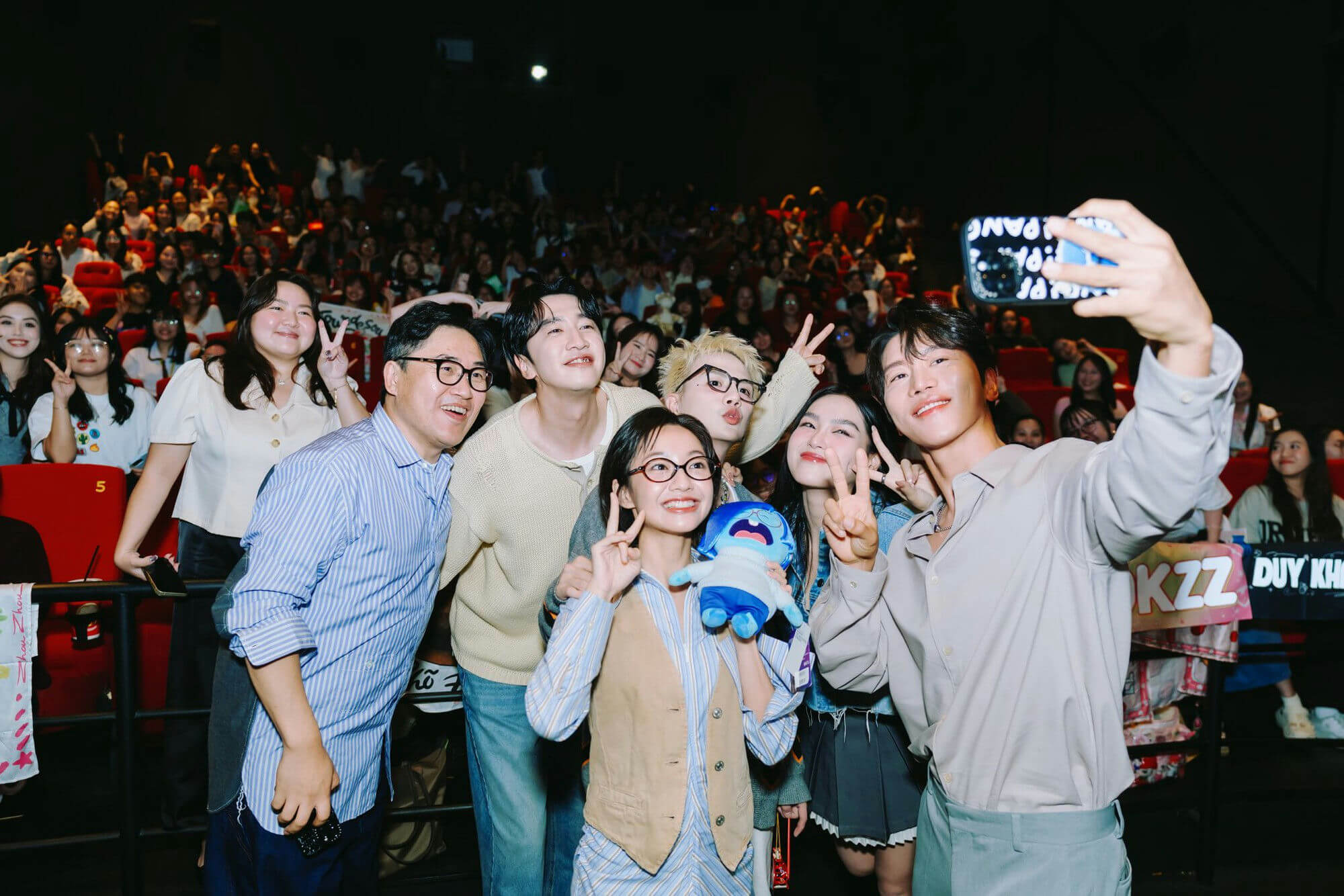 people-7-group selfie-A-theater audience-B-peace signs-C-stuffed toy