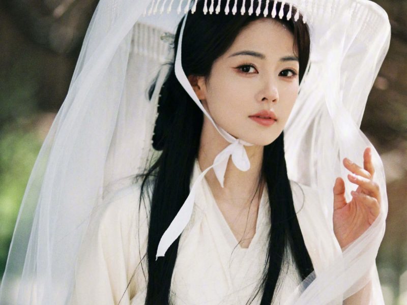 people-woman-white veil-A-traditional Asian attire-A-long black hair-A-outdoor setting-A-soft focus background