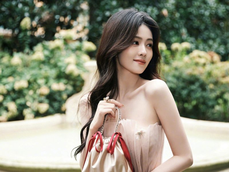 people-A-woman-A-long dark hair-A-strapless pink dress-A-holding small bag