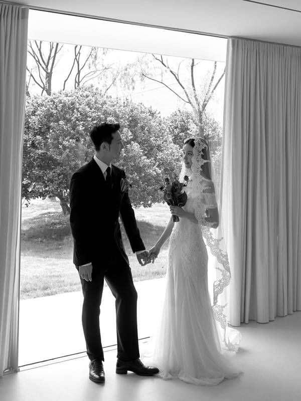 people-A-wedding-A-bride-A-groom-B-holding-hands-B-looking-at-each-other-C-black-and-white-C-window-view