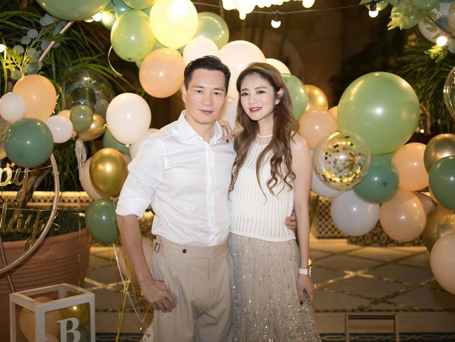 people-A-couple-A-celebration-A-balloons-B-man-B-white-shirt-B-woman-C-beige-dress-C-party-decorations