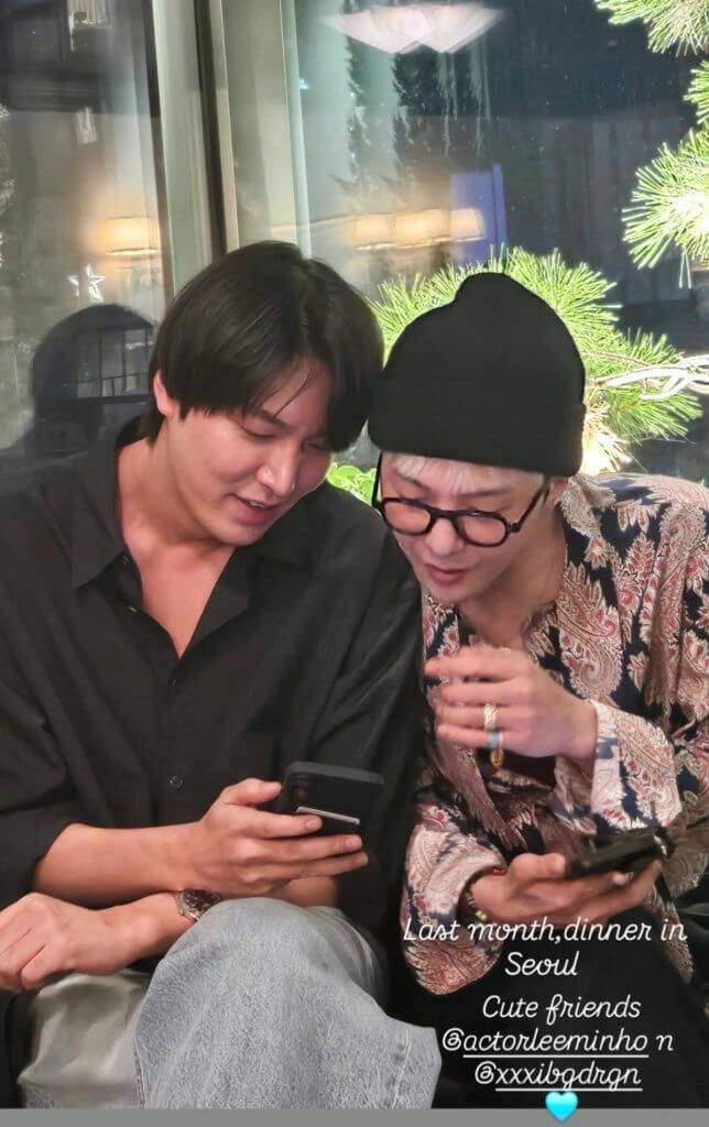 people-Two men-A-looking at phone-B-sitting close together-C-wearing casual attire