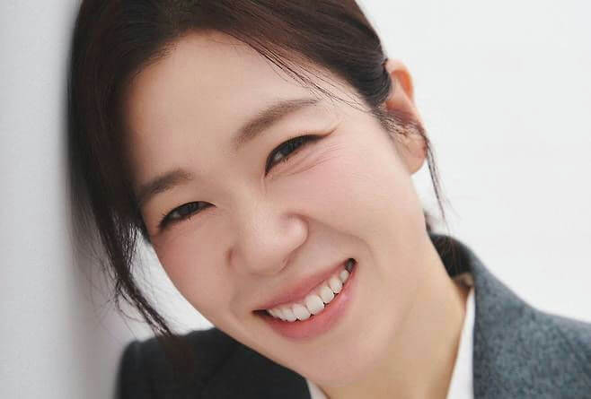 people-woman-A-smiling-A-close-up-B-leaning-against-wall-C-wearing-suit-jacket