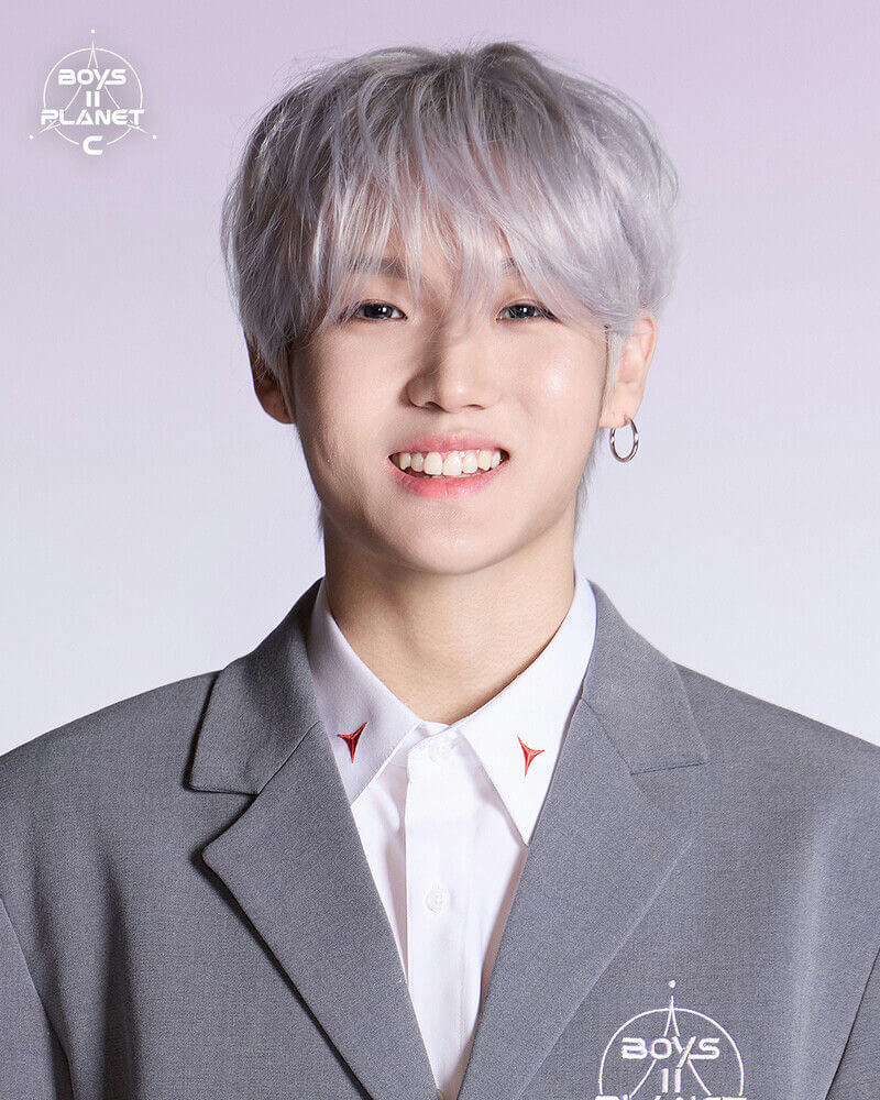 people-One young man-A-K-pop trainee-A-silver/light gray hair-B-smiling broadly-C-gray suit and white shirt with red collar details