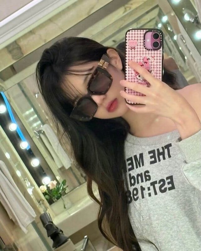 people-1-woman-A-sunglasses-A-selfie-A-pink phone case-B-grey sweatshirt-B-long dark hair-C