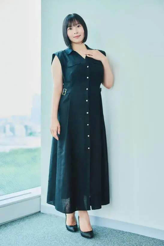 people-woman-black dress-short black hair-leaning against wall-indoor-full body shot