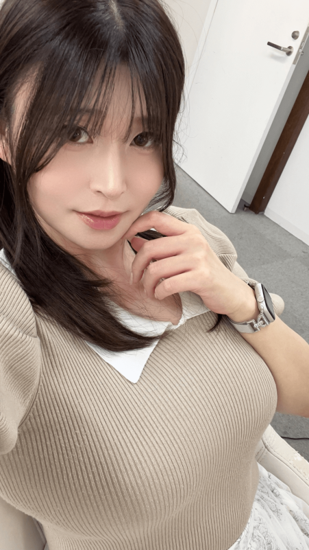 people-woman-A-long dark hair-A-bangs-A-light beige ribbed top-A-white collar-A-hand near chin-A-silver smartwatch-A-pink glossy lips