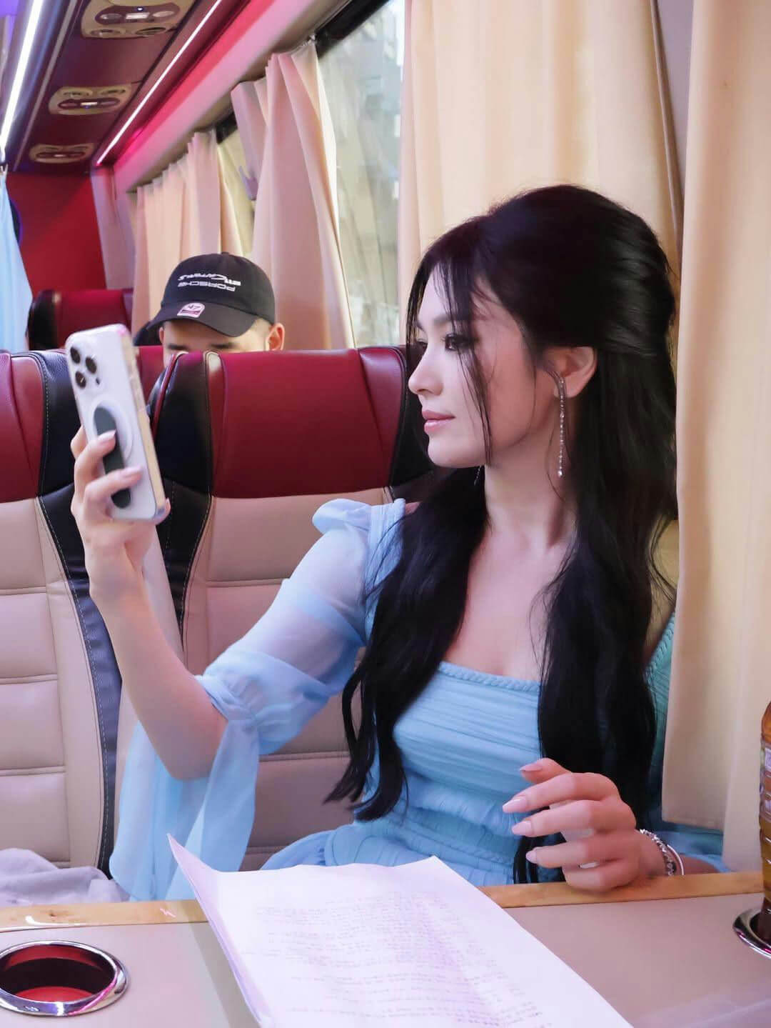 people-woman-A-blue dress-B-holding phone-C-bus interior