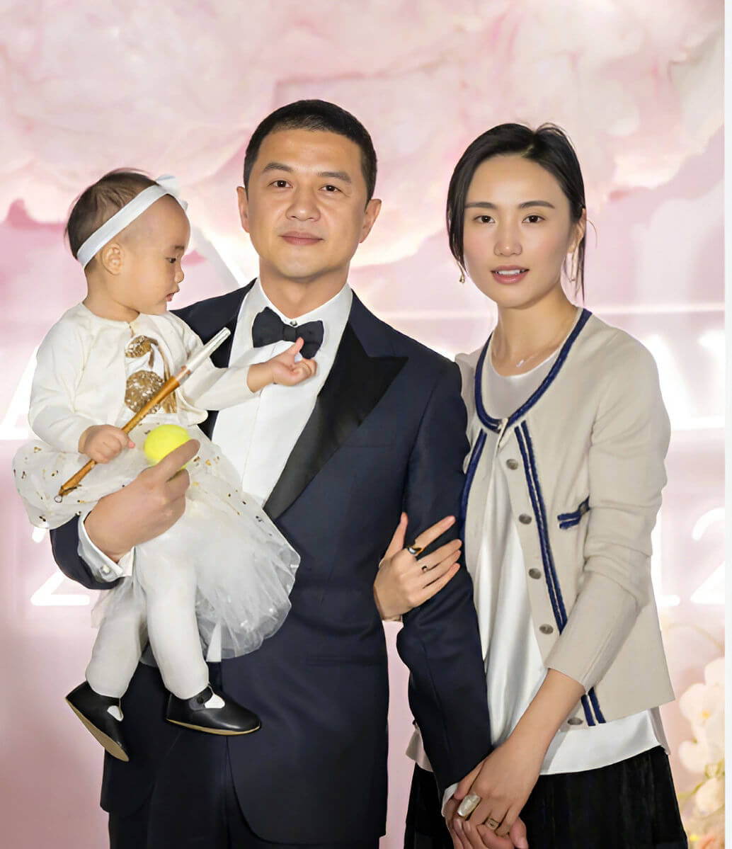 people-man-in-tuxedo-woman-in-cardigan-baby-in-white-dress