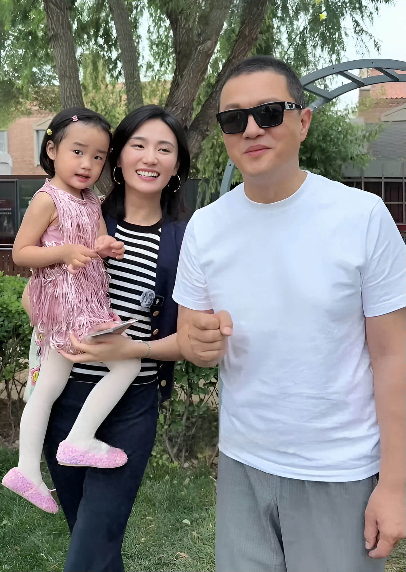 people-A-Family portrait-A-Outdoor setting-A-Woman holding child-A-Man wearing sunglasses