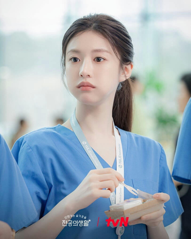 people-A-female-A-doctor/nurse-A-blue scrubs-A-eating-A-lanyard