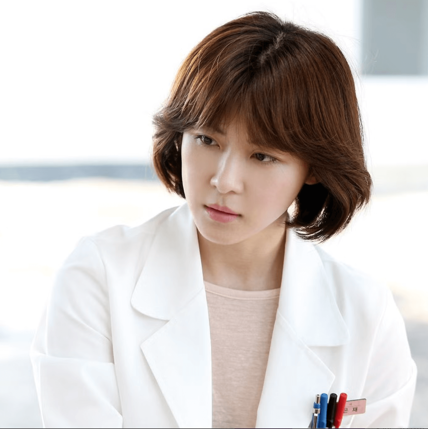 people-A-woman-A-short brown hair-A-white lab coat-A-looking down