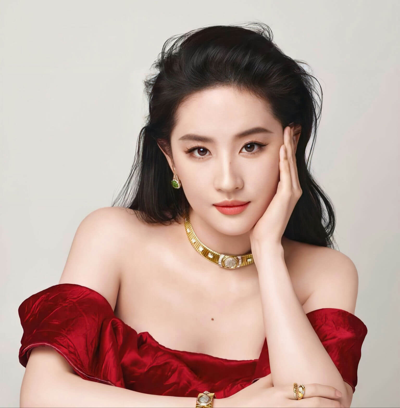 people-woman-A-red dress-A-gold jewelry-A-off-the-shoulder-A-dark hair-A-hand on face