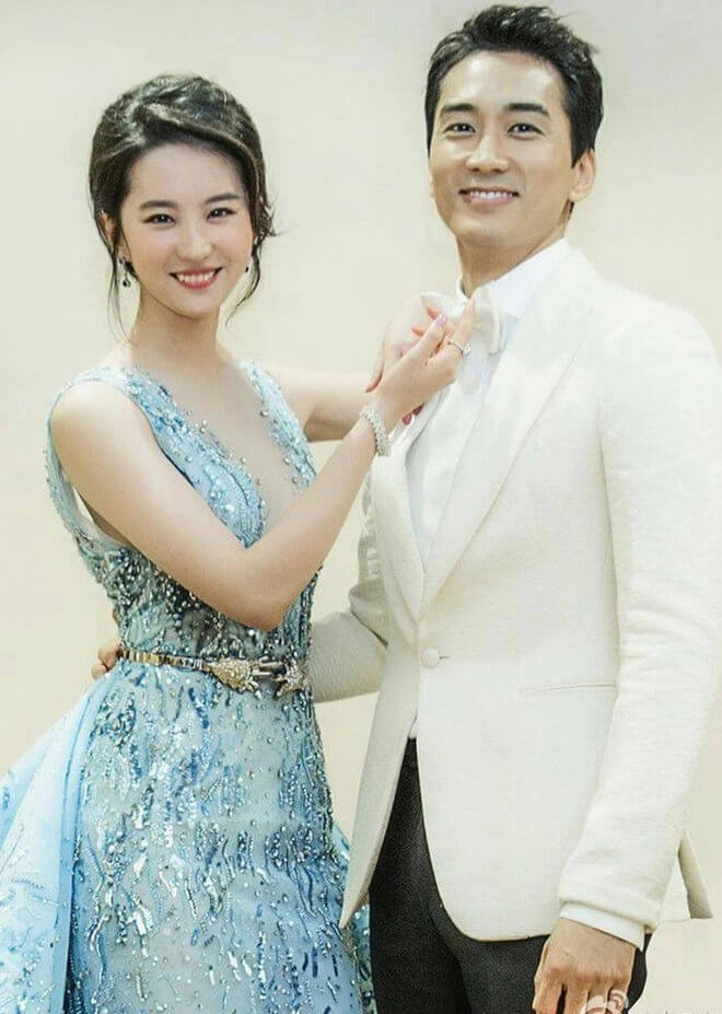 people-A-woman in blue embellished gown-A-man in white tuxedo jacket-B-smiling-C-adjusting bowtie