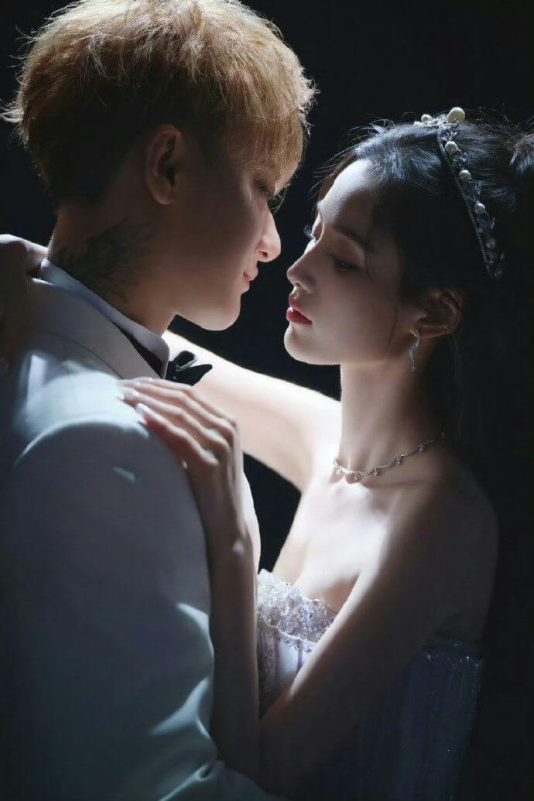 people-A-couple embracing-A-dramatic lighting-A-formal attire-A-intense gaze