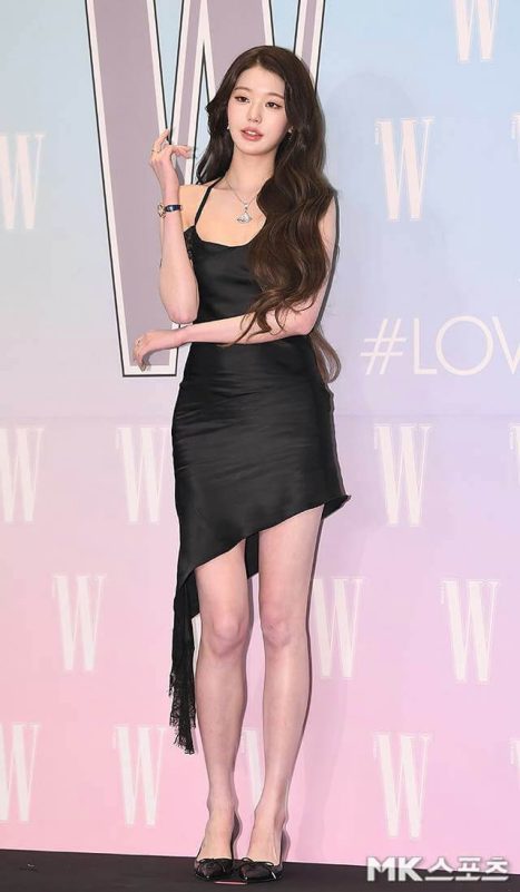 people-A-woman-A-black dress-A-long brown hair-A-asymmetrical hem-A-jewelry-A-high heels-A-W Korea background