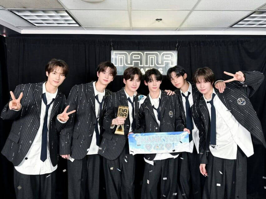 people-six young men-A-K-pop idols-A-formal attire-A-MAMA Awards-A-trophy-A-thank you banner-A-posing-A-victory signs