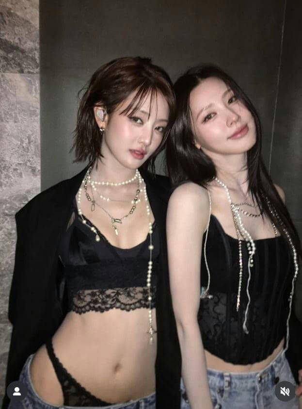 people-Two young women-A-dark clothing-A-pearl necklaces-A-low-rise jeans-B-indoor setting-B-korean pop style-C-belly exposed