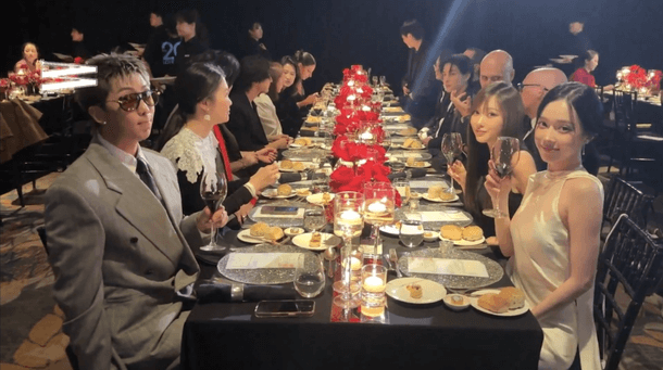 people-Man in grey suit and sunglasses-A-dining-A-formal dinner-B-Women raising wine glasses-C-Red roses and candles centerpiece