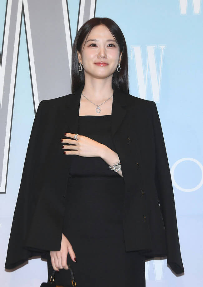 people-Korean actress/celebrity-A-wearing-A-black outfit-B-accessorized with-B-diamond jewelry-C-posing at an event-C-in front of a W Korea backdrop