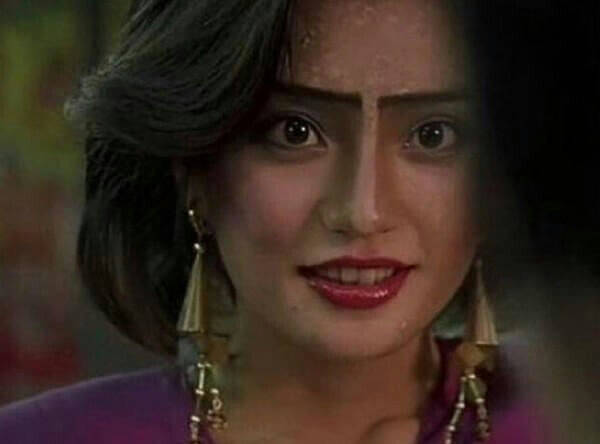 people-A-Asian woman-A-striking makeup-A-unibrow-A-large dangling earrings-A-intense gaze