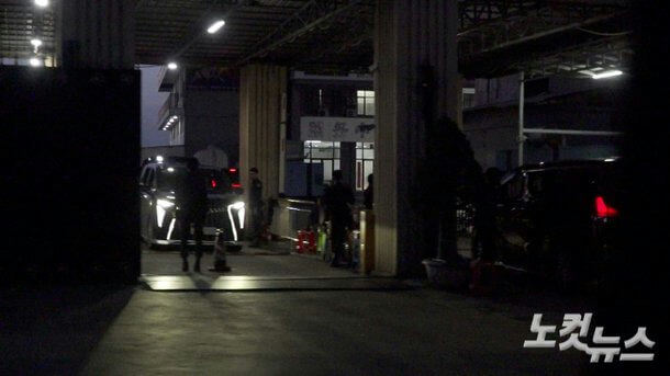 people-several silhouettes-A-darkness-A-vehicle with bright daytime running lights-B-covered entryway or garage-C