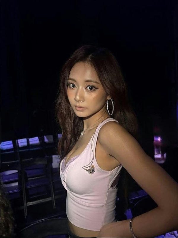 people-1-woman-A-long brown hair-A-pink tank top-A-large hoop earrings