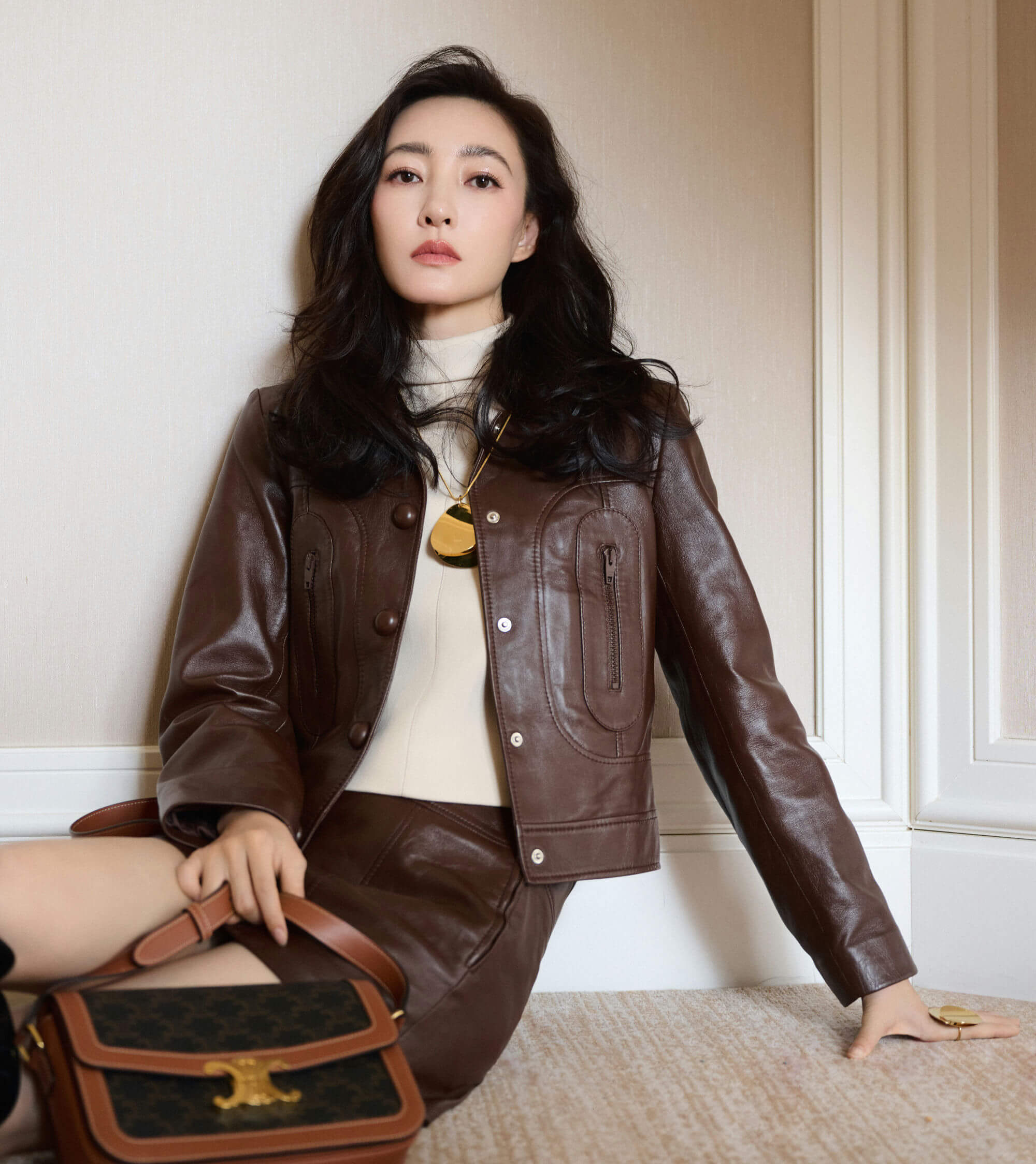 people-A-woman-A-sitting-on-floor-A-brown-leather-jacket-B-turtleneck-sweater-C-Celine-bag